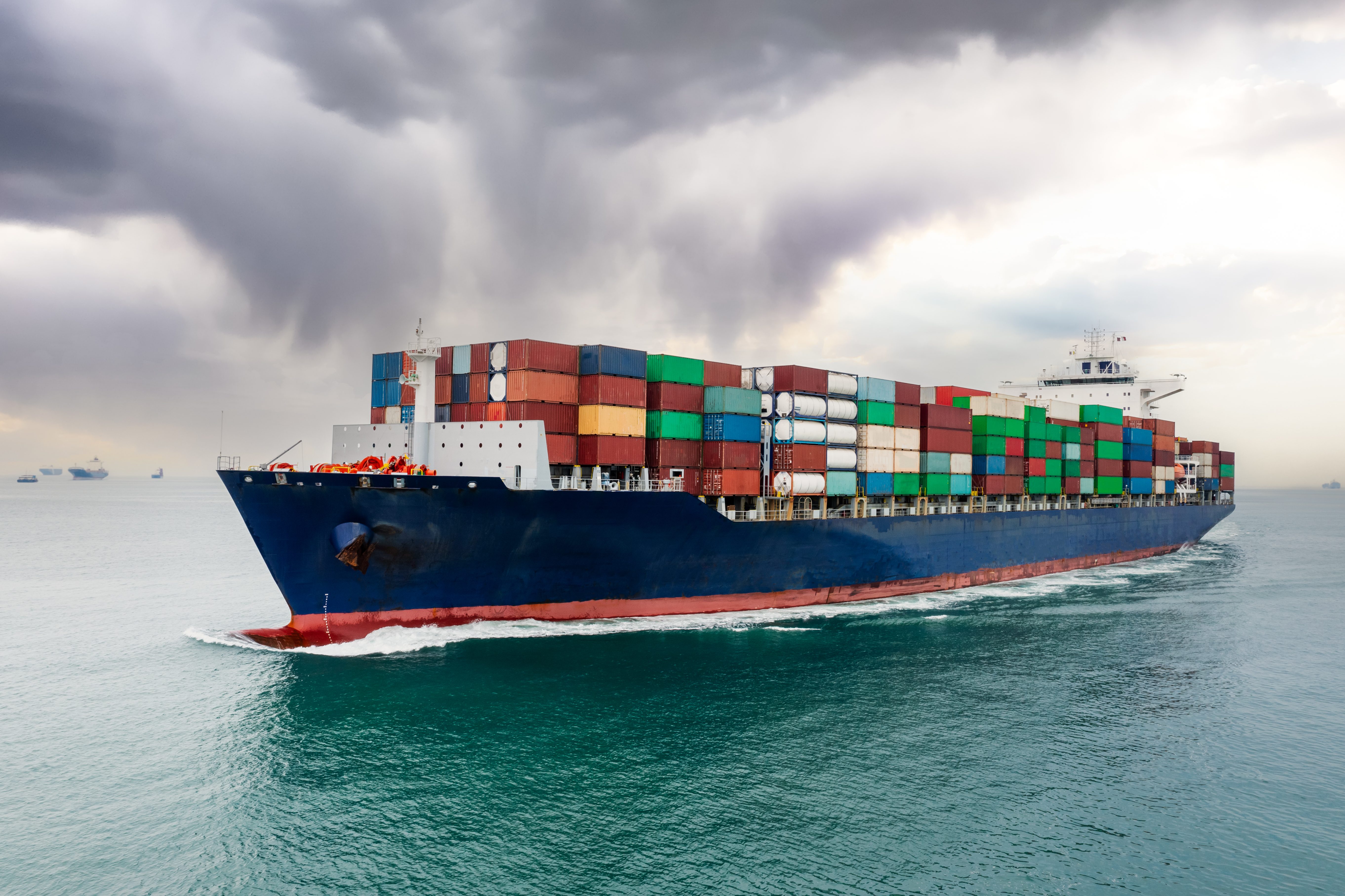 Container ship sailing to transport goods in containers for import export internationally and worldwide.