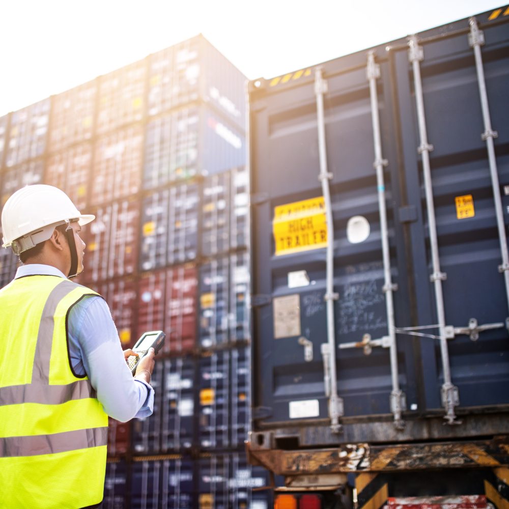 Foreman control loading Containers box from Cargo freight ship for import export.