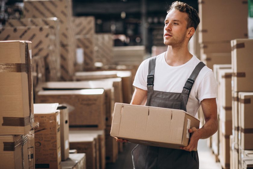 Young man working at a warehouse with boxes.